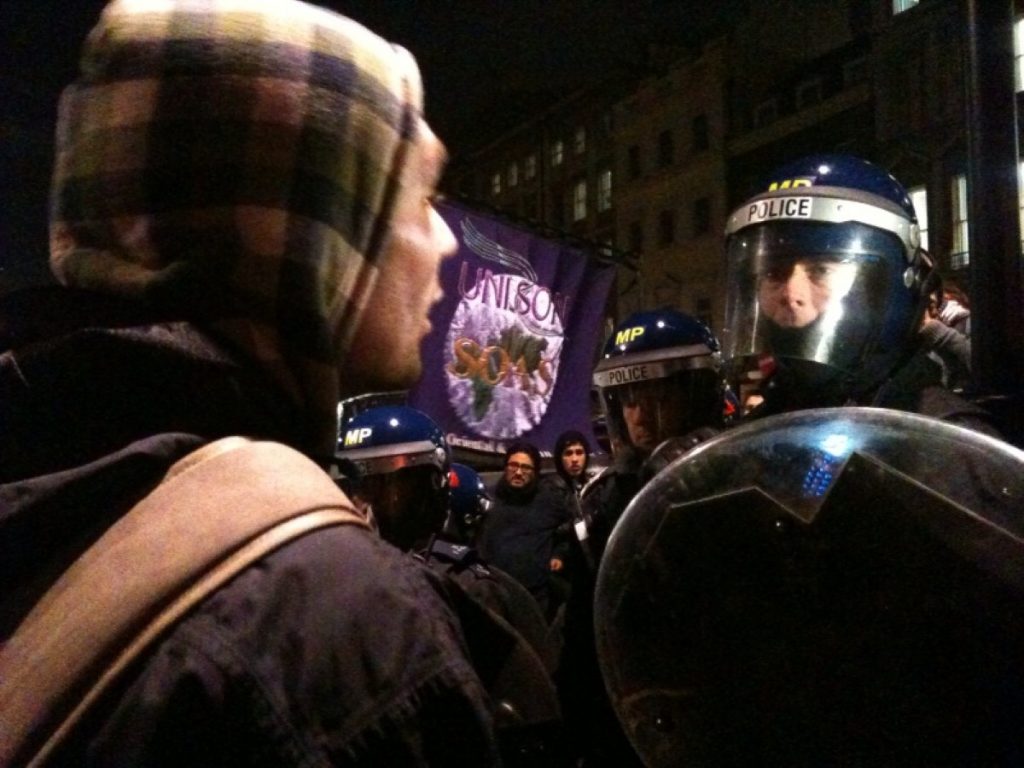 A protestor confronts a policeman in Whitehall during the tuition fees demonstration