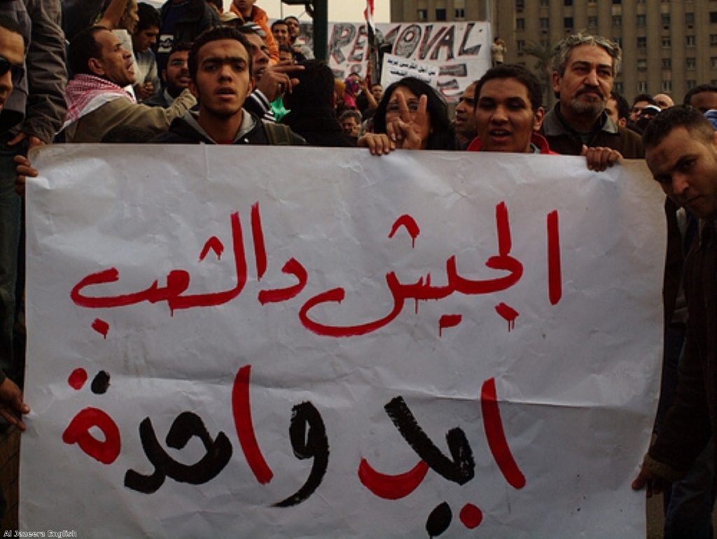 A banner reads 'the army and the people are one' during a protest before the Egyptian revolution in 2011.