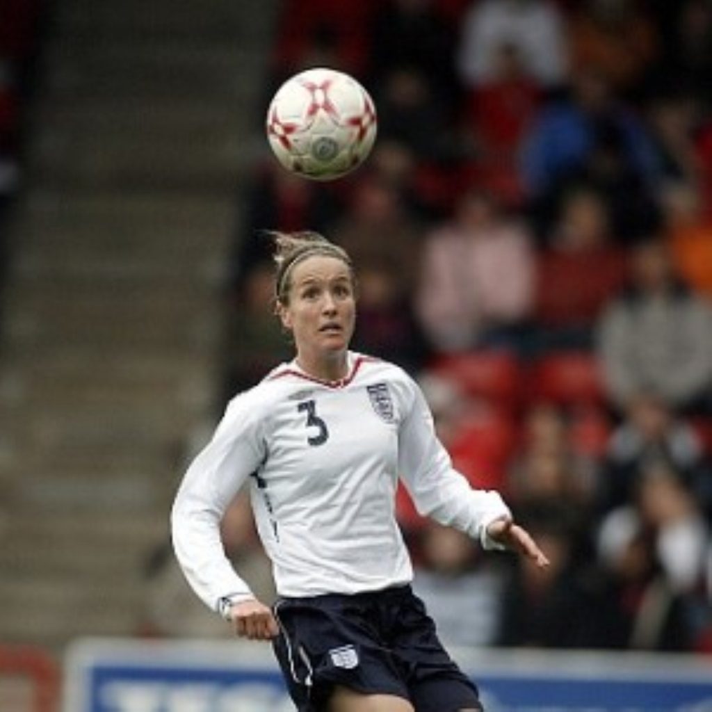 Casey Stoney headers a ball for England. Women