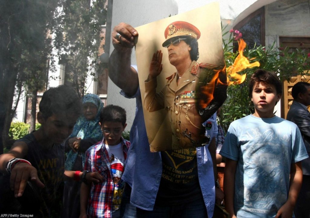 Demonstrators set fire to a poster of Gaddafi outside the Libyan embassy in Ankara yesterday. Jubilation at the regime's collapse appears to have been shortlived.