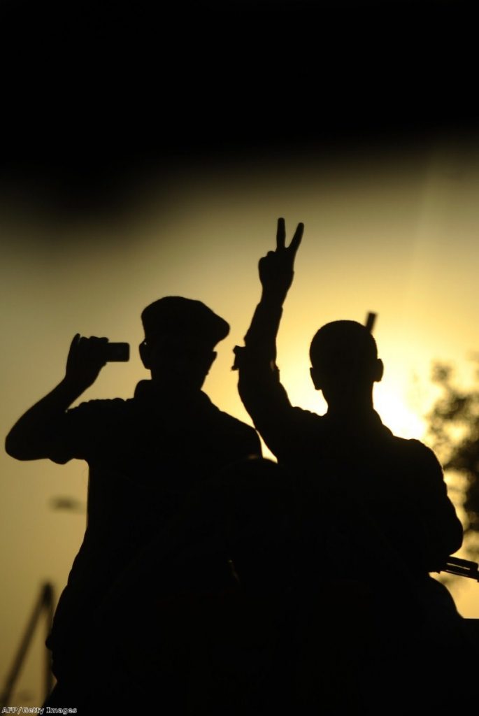 A rebel flashes the V-sign for victory during celebrations in the newly named Martyr's Square yesterday.