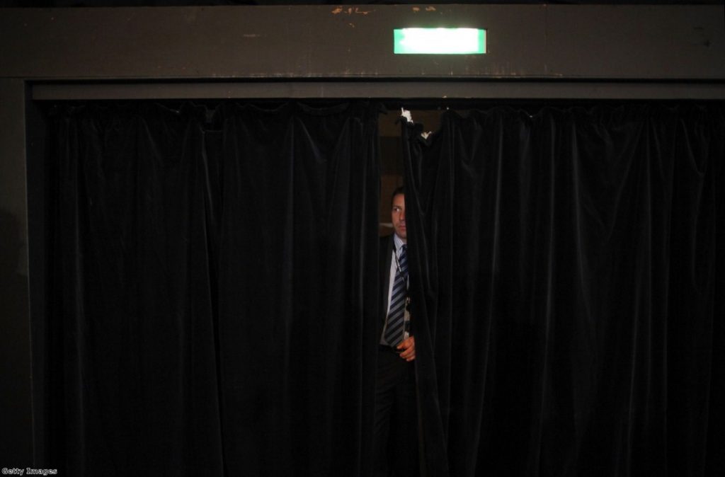 A member of security watches through a curtain while Nick Clegg conducts a Q&A in Birmingham. The party leadership was anxious about another vote on NHS reform.