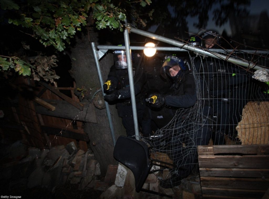 Police fire Tasers as they break through a barricade during evictions from Dale Farm travellers camp in 2011
