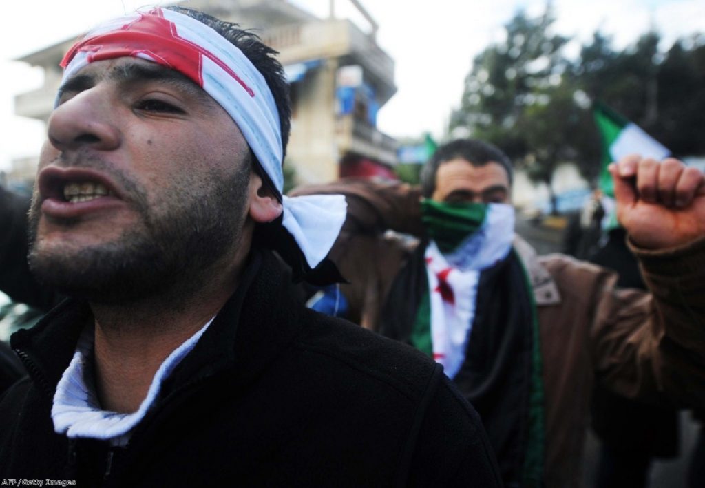 Men protest against Syrian repression in Algeria over the weekend. The violence has prompted outrage across the globe.