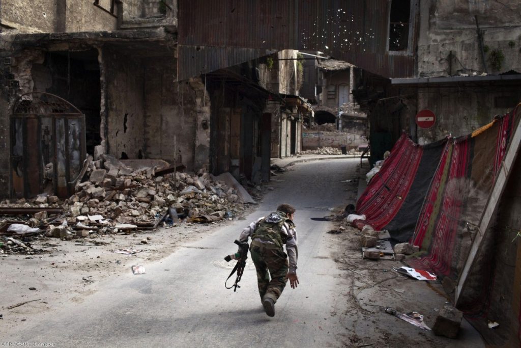 A Syrian rebel crosses a street while trying to dodge sniper fire in Aleppo. More than 11.5 million Syrians are now thought to be in need of help. 