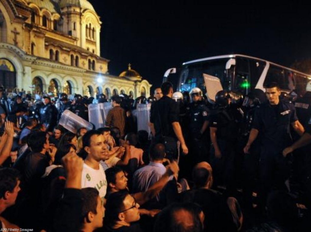 Protesters outside the Bulgarian parliament block a bus containing MPs from leaving