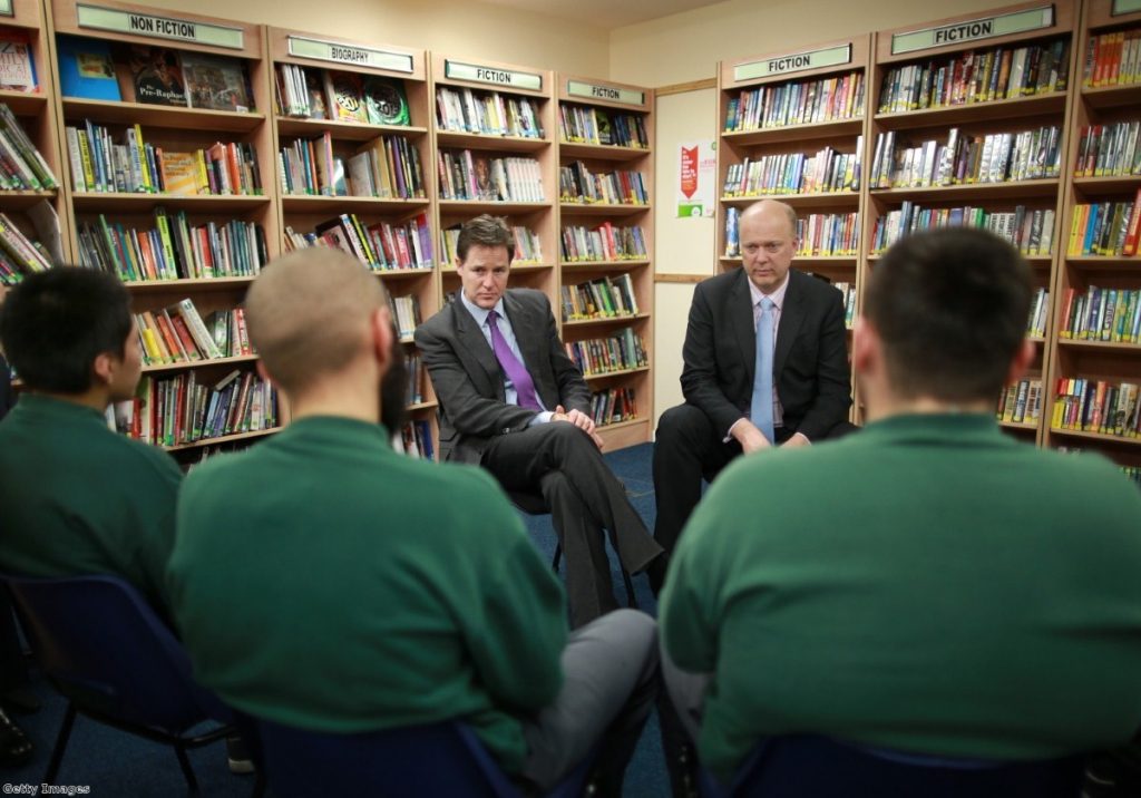 Clegg and Grayling speak to inmates in a prison library - the Lib Dems have stood shoulder-to-shoulder with the justice secretary over the prisoner book ban