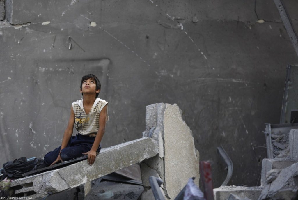 Palestinian boy sits on the rubble of a destroyed building following an Israeli air strike earlier today. Air strikes killed at least seven people in Gaza, including five members of the same family, an emergency services spokesman said.