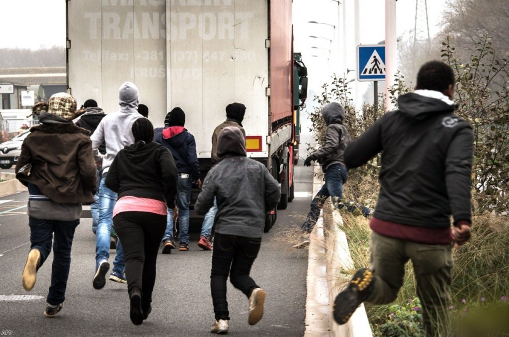 Migrants and asylum seekers try to get into the UK on the back of lorries in Calais