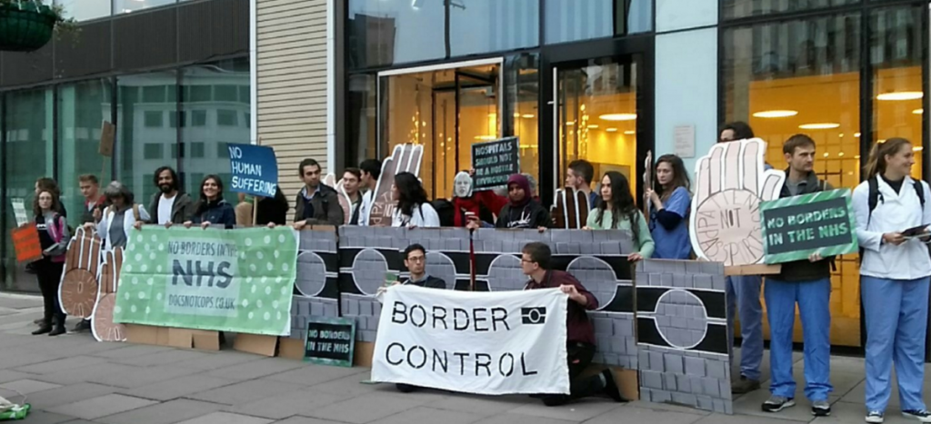 "Healthcare professionals and activists set up an 'immigration checkpoint' outside the government building to highlight the policy"
