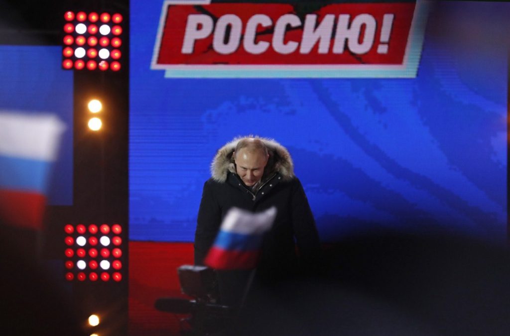 Putin addresses supporters during a rally near the Kremlin yesterday, as he coasts to another election victory