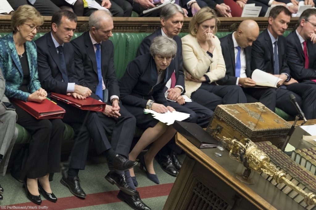 Theresa May leans forward during PMQs. She is reluctantly allowing domestic preparation to start for European elections.