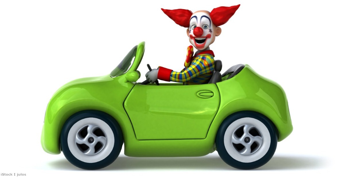 A clown-car, tottering down a high speed motorway, surrounded by heavy-duty vehicles travelling at speed.