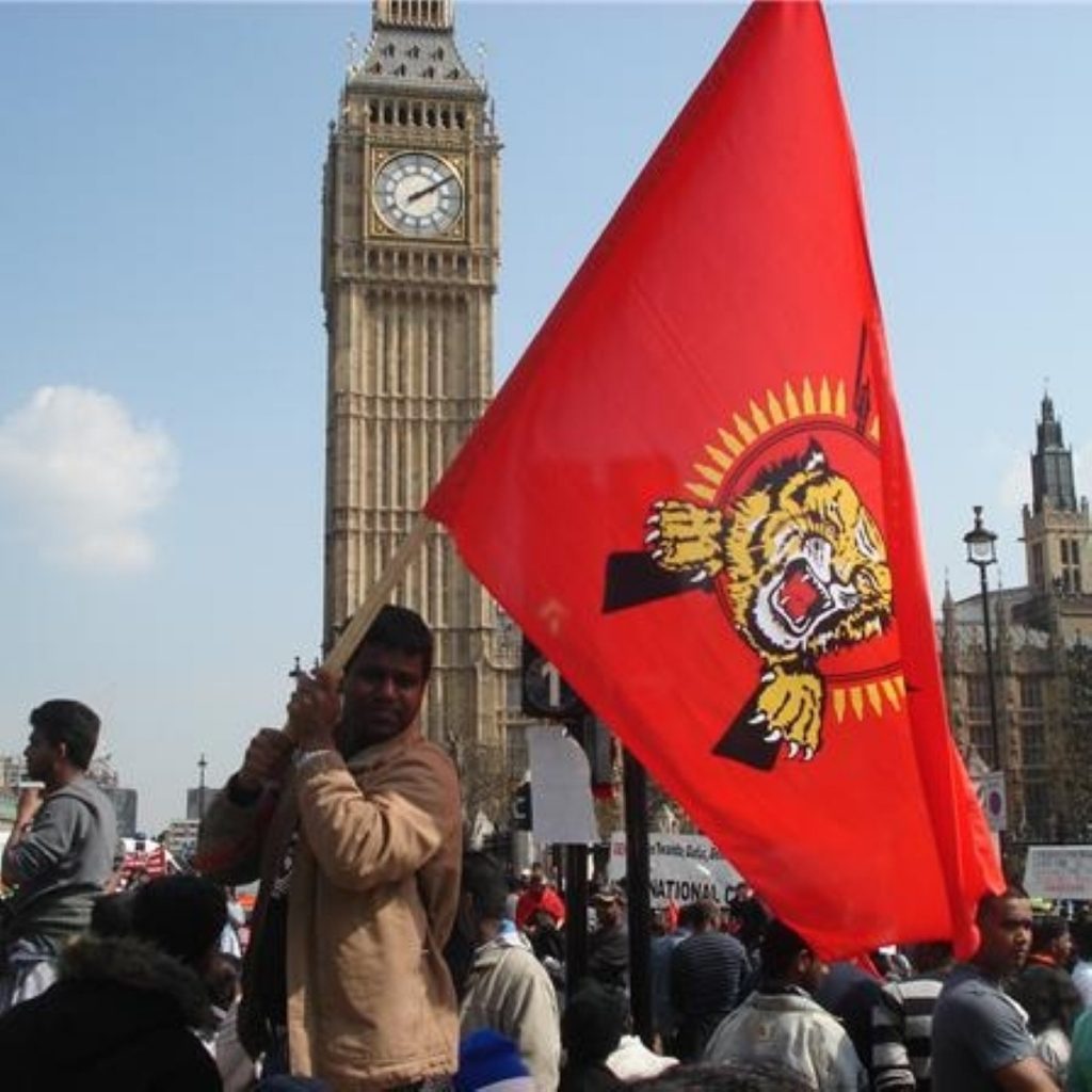 A protestor waves the Tamil flag outside parliament
