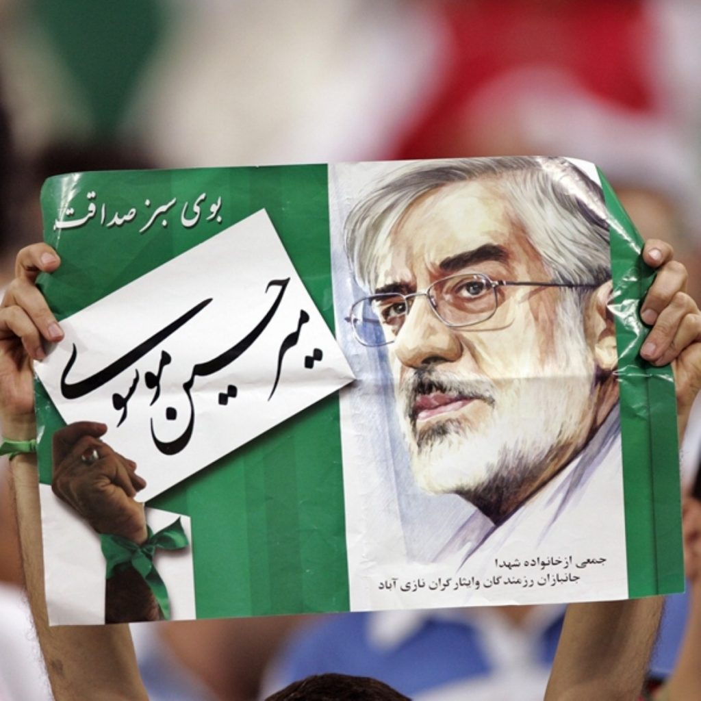 A demonstrator holds up an image of opposition leader Mir-Hossein Mousavi