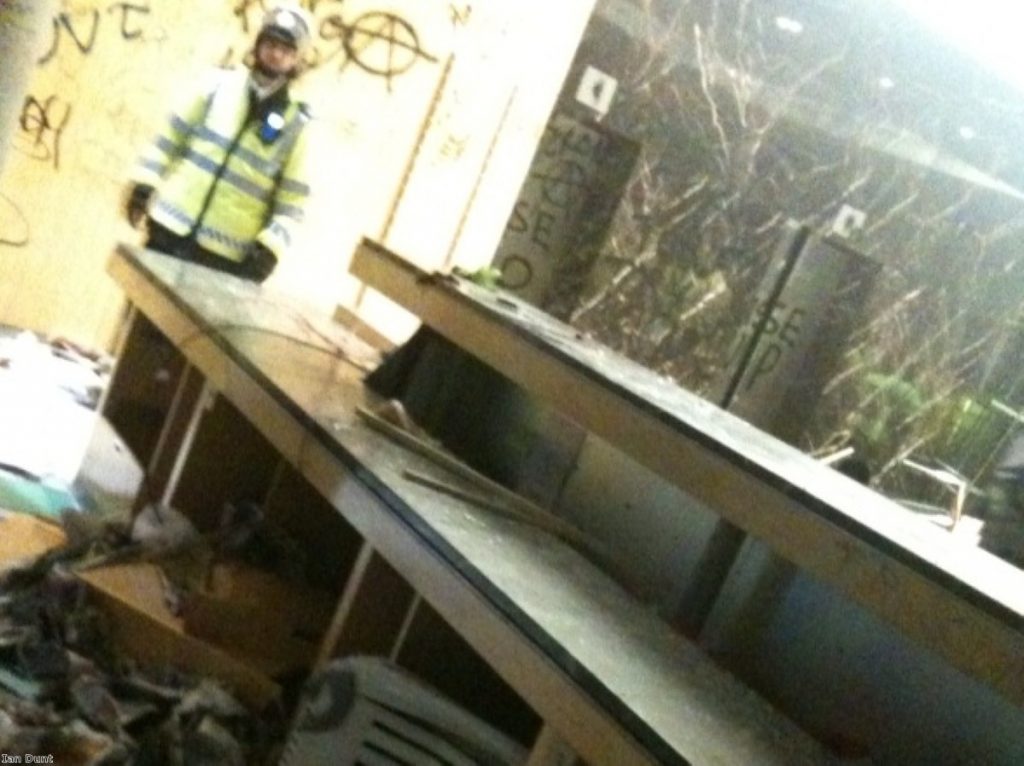 A policeman stares at the remains of the Millbank foyer after the occupation yesterday