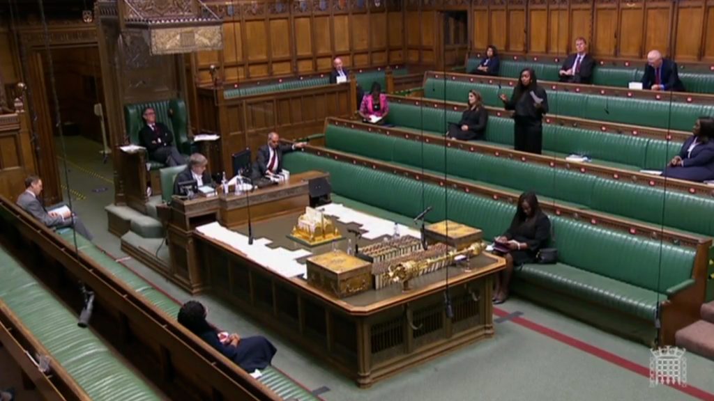 Wide view of Dawn Butler on her feet speaking in the House of Commons with MPs socially distanced during Black History month debate